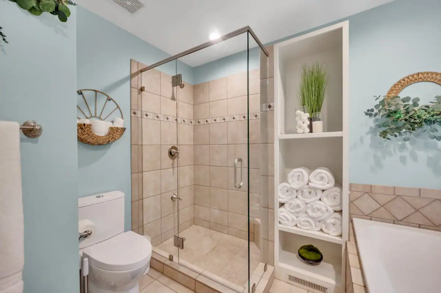 Tiled shower with glass doors.